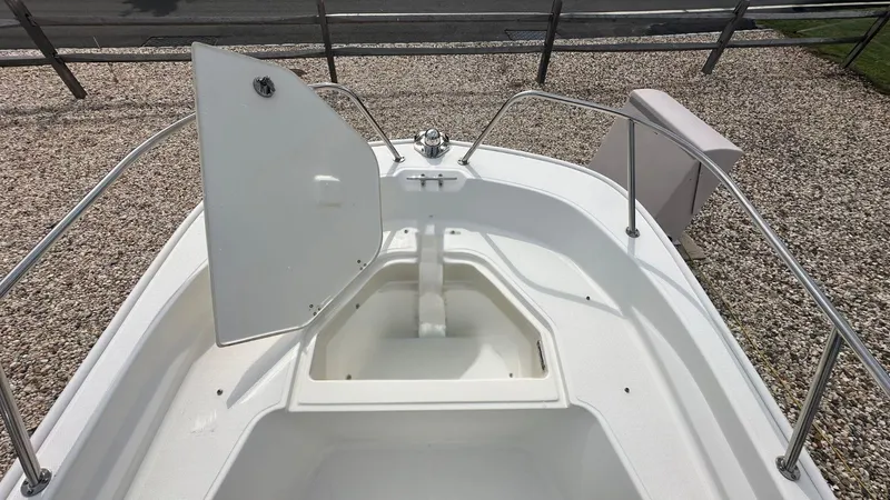 Slide: The Image of 2022 Boston Whaler 150 Montauk boat with open storage compartment on deck. - 22