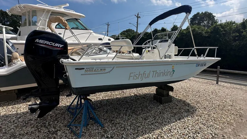 Slide: The Image of 2022 Boston Whaler 150 Montauk boat with Mercury engine on display outdoors. - 25