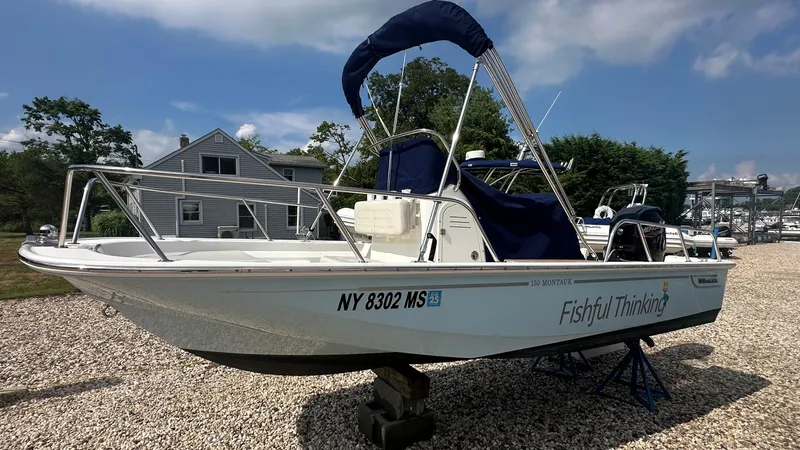 Slide: The Image of 2022 Boston Whaler 150 Montauk boat on display, named "Fishful Thinking," with blue canopy. - 3