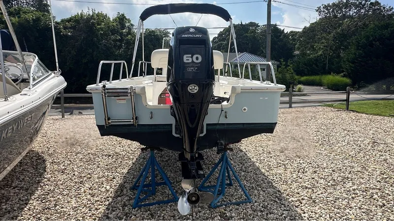 Slide: The Image of 2022 Boston Whaler 150 Montauk with Mercury 60 HP engine on display outdoors. - 4