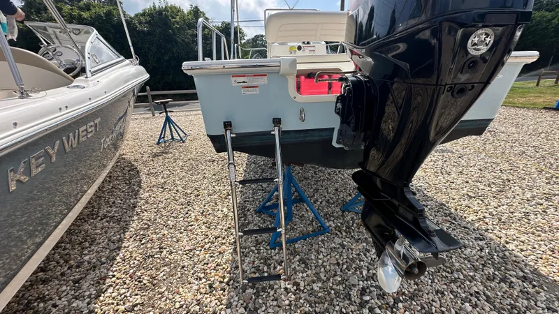 Slide: The Image of 2022 Boston Whaler 150 Montauk boat with outboard motor on gravel lot. - 5