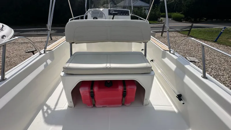 Slide: The Image of 2022 Boston Whaler 150 Montauk interior with seating and storage compartment. - 8