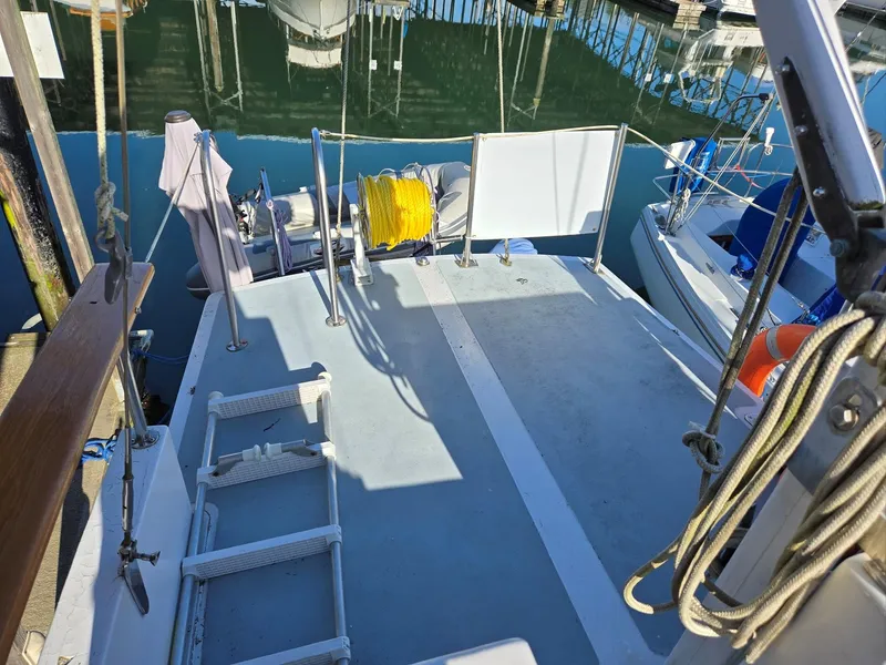 Slide: The Image of 1974 Willard Nomad boat deck with wooden hatch and nearby docked boats. - 11