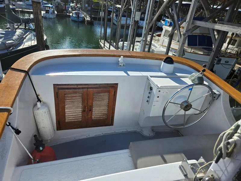 Slide: The Image of 1974 Willard Nomad boat with ladder and wooden door, docked at marina. - 14