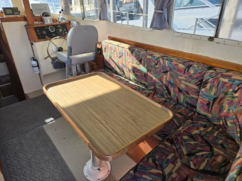 Slide: The Image of 1974 Willard Nomad boat interior with kitchenette, table, and window view of marina. - 24