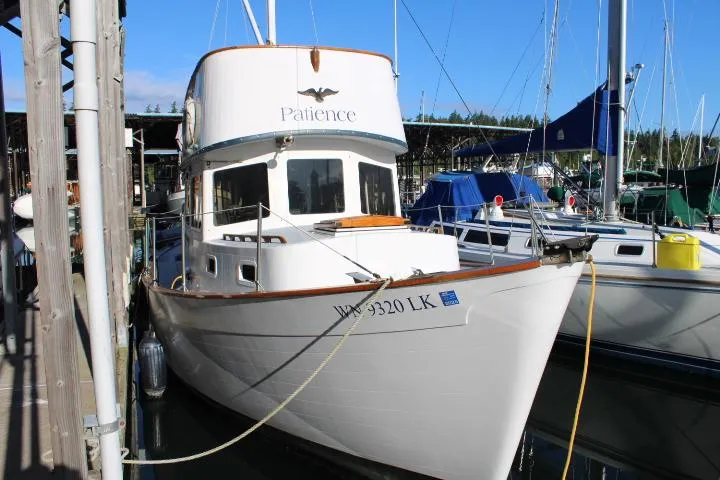 Slide: The Image of 1974 Willard Nomad boat named "Patience" docked at a marina. - 3