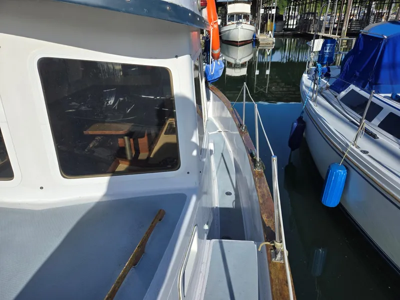 Slide: The Image of 1974 Willard Nomad boat docked at sunset with silhouetted figures on the pier. - 8