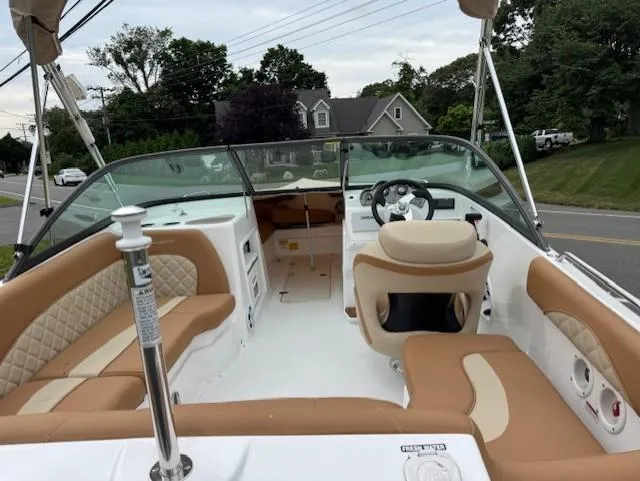Slide: The Image of 2025 NauticStar 203 DC Deck boat with tan seating and modern dashboard. - 15