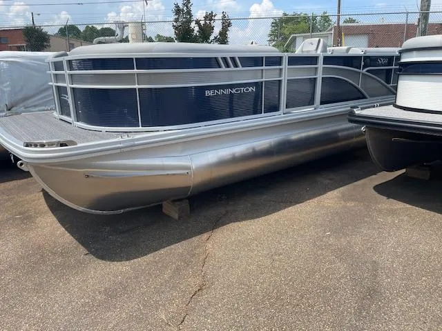 The Image of 2024 Bennington 22SXSR pontoon boat parked on pavement, showcasing sleek design and modern features. - 1