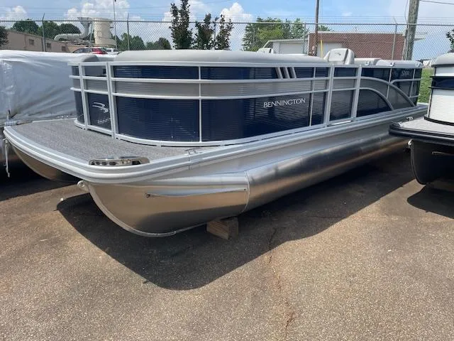 Slide: The Image of 2024 Bennington 22SXSR pontoon boat in a parking lot, side view. - 2