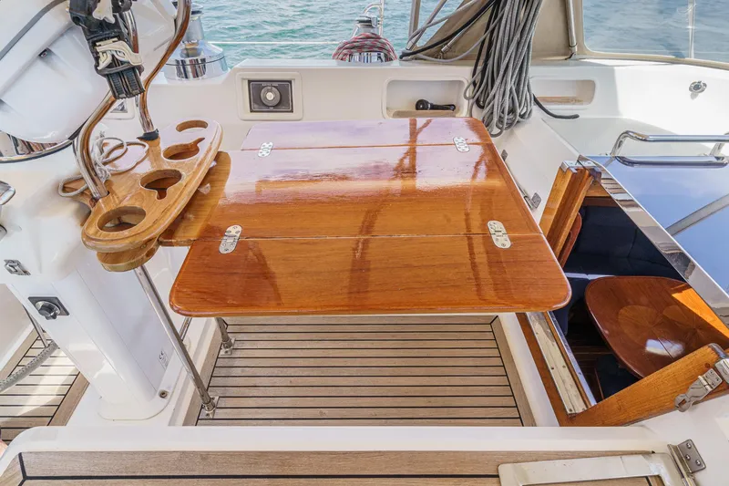 Slide: The Image of Cockpit of 2001 Hylas 49 yacht with polished wooden table and seating area. - 20