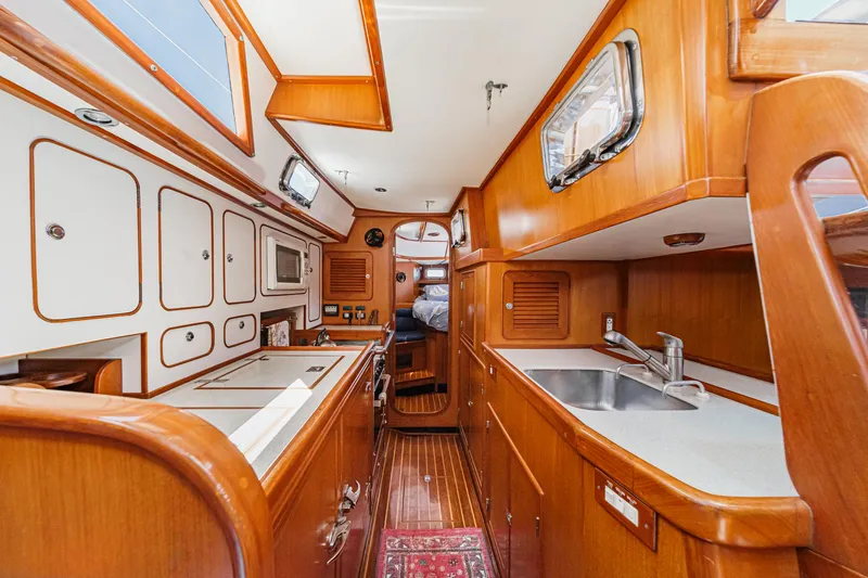 Slide: The Image of Interior of 2001 Hylas 49 yacht with wooden cabinetry and modern kitchen amenities. - 29
