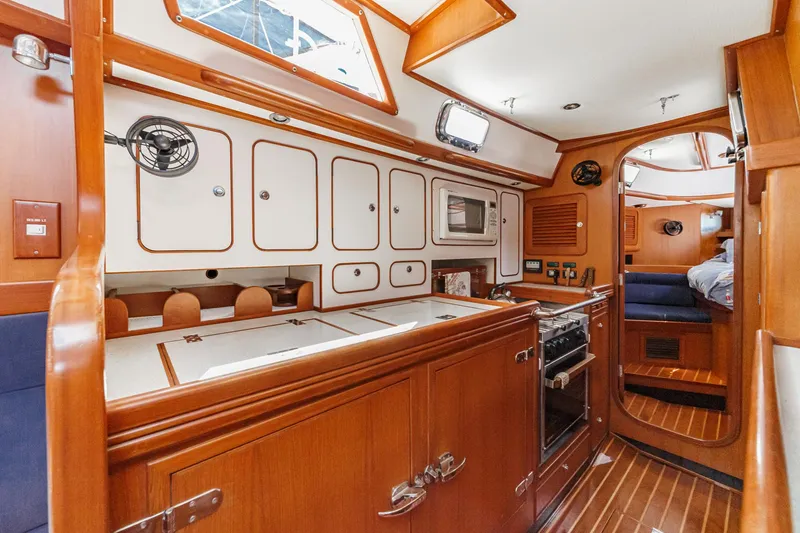 Slide: The Image of Interior of 2001 Hylas 49 yacht featuring a well-equipped galley and cozy cabin space. - 30