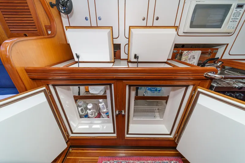 Slide: The Image of Interior of a 2001 Hylas 49 yacht kitchen with open cabinets and microwave. - 31