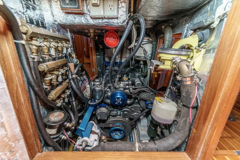 Slide: The Image of Engine room of a 2001 Hylas 49 yacht, showcasing complex machinery and wiring. - 37