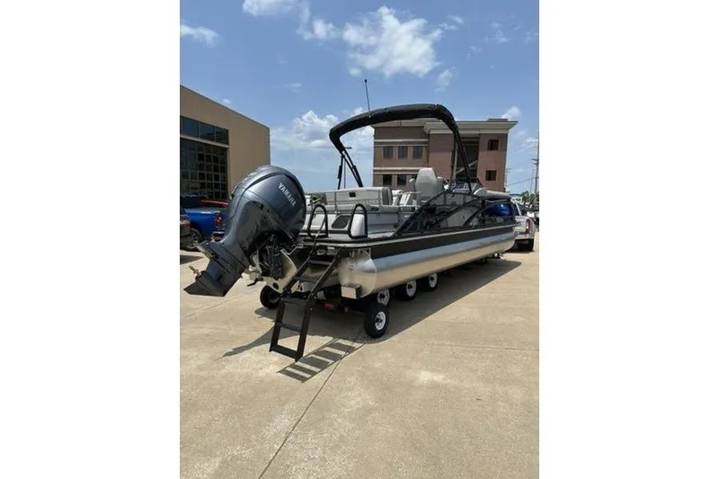 Slide: The Image of 2025 Bennington 25 QSBA pontoon boat with Yamaha outboard motor on a trailer. - 14