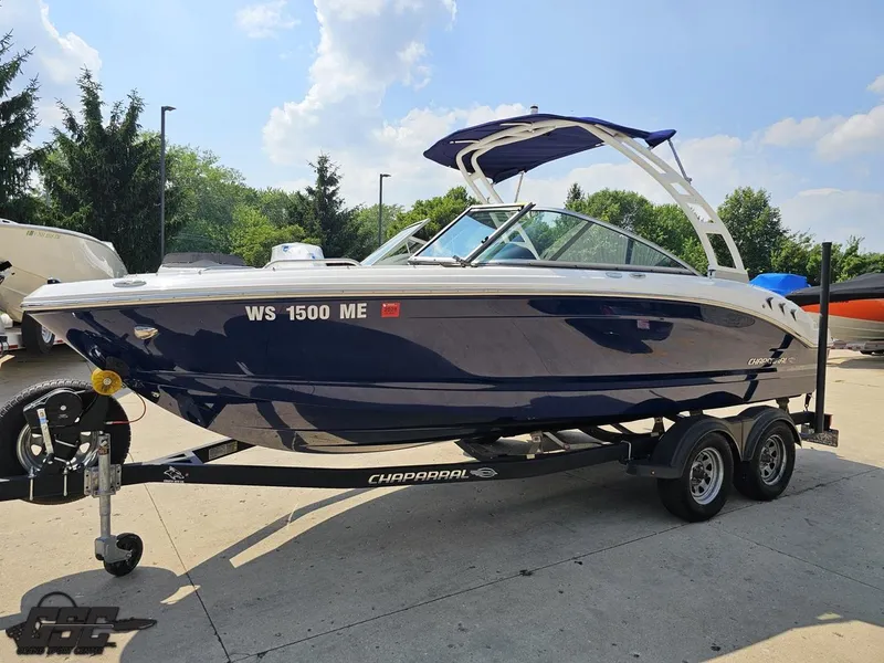 Slide: The Image of 2022 Chaparral 21 SSi boat on trailer, parked outdoors under a clear sky. - 22
