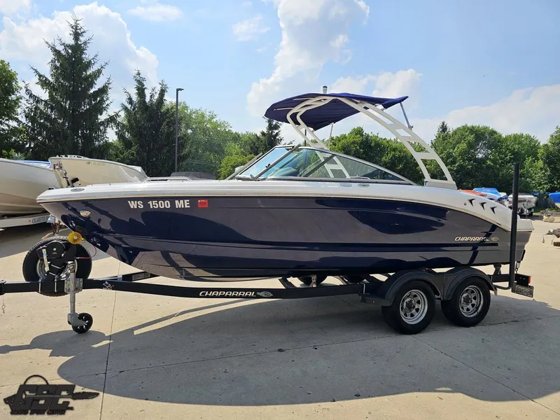 Slide: The Image of 2022 Chaparral 21 SSi boat on trailer, parked outdoors under a clear sky. - 23