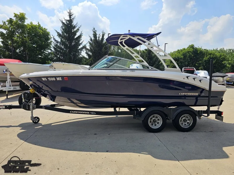 Slide: The Image of 2022 Chaparral 21 SSi boat on trailer, parked outdoors, sunny day. - 24