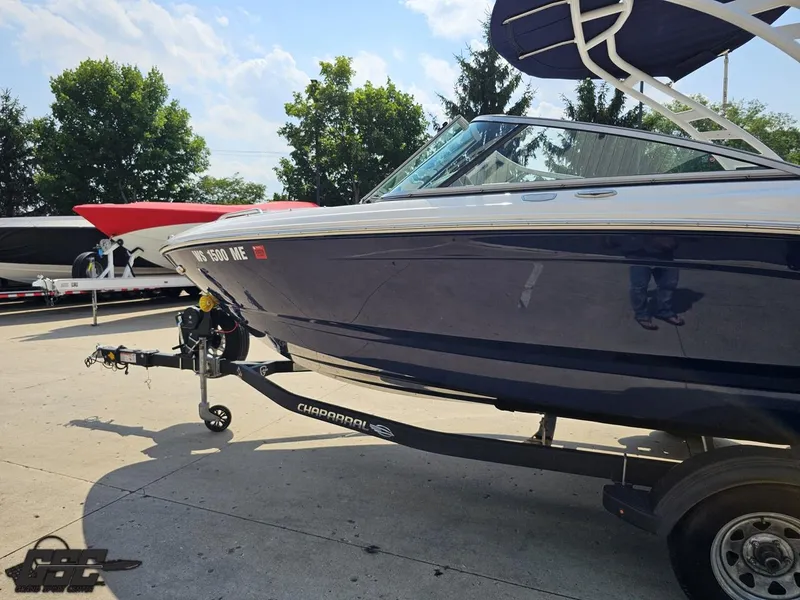 Slide: The Image of 2022 Chaparral 21 SSi boat on trailer, parked outdoors under a clear sky. - 27