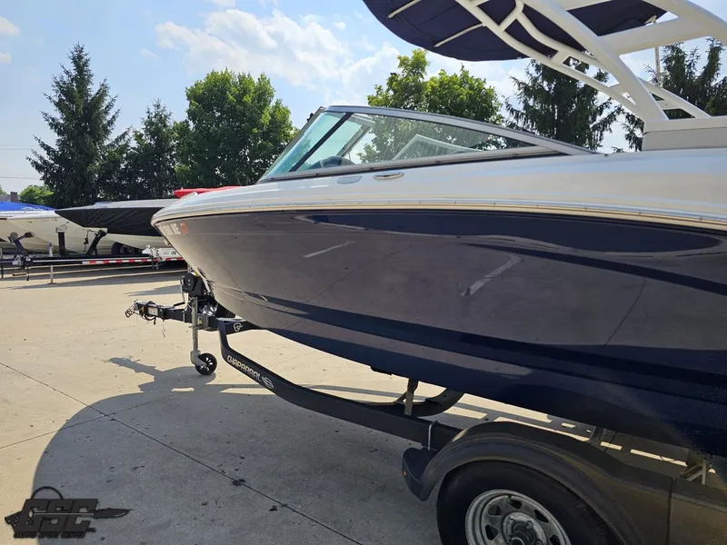 Slide: The Image of 2022 Chaparral 21 SSi boat on trailer, parked outdoors under clear sky. - 30
