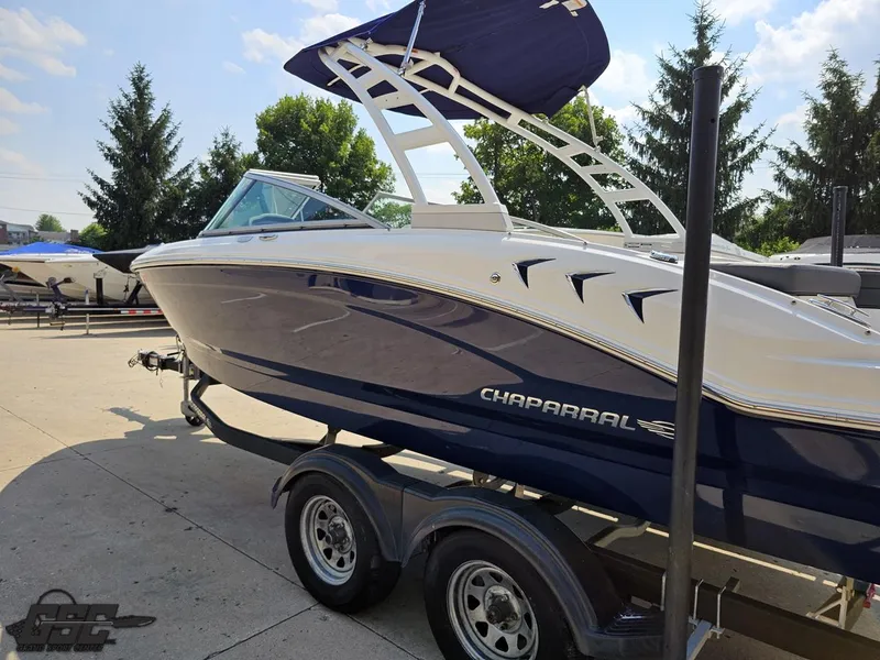 Slide: The Image of 2022 Chaparral 21 SSi boat on trailer, parked outdoors under clear sky. - 31