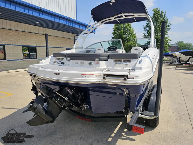 Slide: The Image of 2022 Chaparral 21 SSi boat with outboard motor, parked outdoors on a sunny day. - 36