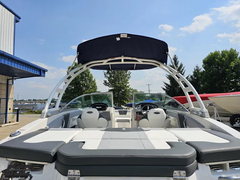 Slide: The Image of 2022 Chaparral 21 SSi boat with sleek seating and canopy, docked under a clear sky. - 43