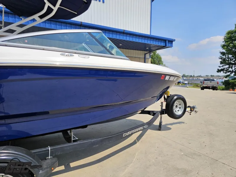 Slide: The Image of 2022 Chaparral 21 SSi boat on trailer, blue hull, parked outdoors. - 5