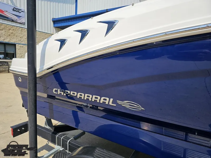 Slide: The Image of 2022 Chaparral 21 SSi boat in blue and white, displayed outdoors. - 7