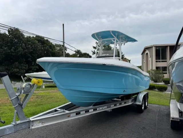 Slide: The Image of 2025 NauticStar 222L Offshore boat on trailer, blue hull, parked outdoors. - 3