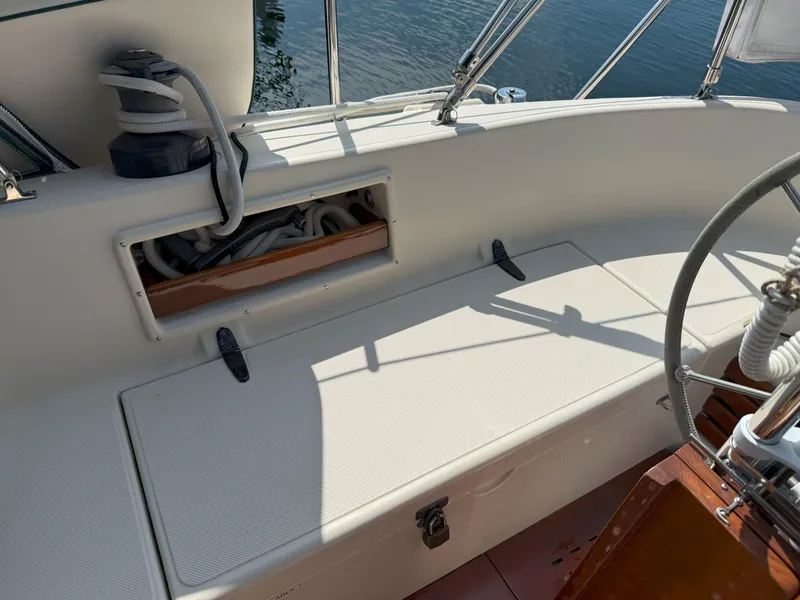 Slide: The Image of 1993 Pacific Seacraft Crealock 34 cockpit with storage and steering wheel, docked by water. - 18