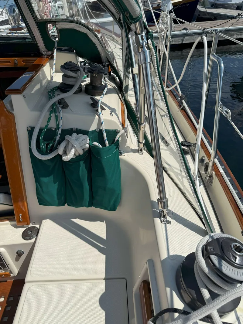 Slide: The Image of 1993 Pacific Seacraft Crealock 34 sailboat deck with green storage bags and winches. - 23