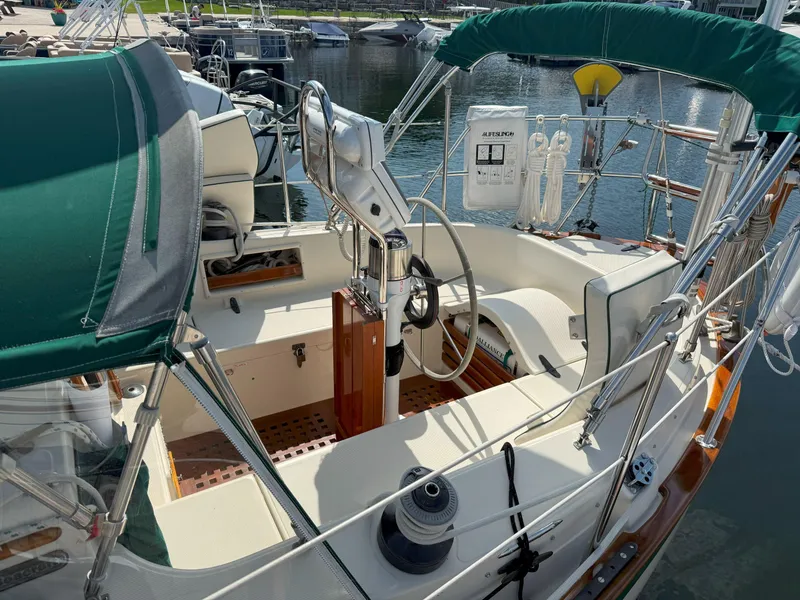 Slide: The Image of Cockpit of 1993 Pacific Seacraft Crealock 34 sailboat with green canopy and marina view. - 4