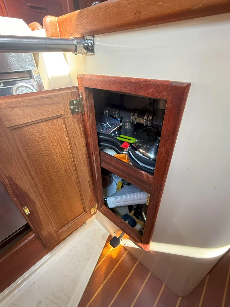 Slide: The Image of Open cabinet on 1993 Pacific Seacraft Crealock 34 sailboat, showing interior storage and equipment. - 43