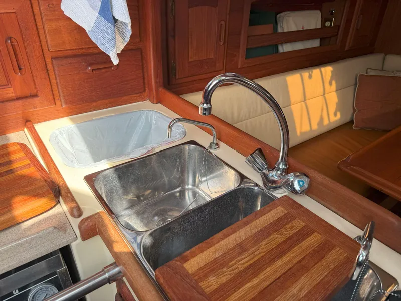 Slide: The Image of Galley of 1993 Pacific Seacraft Crealock 34 with stainless steel sink and wooden accents. - 45