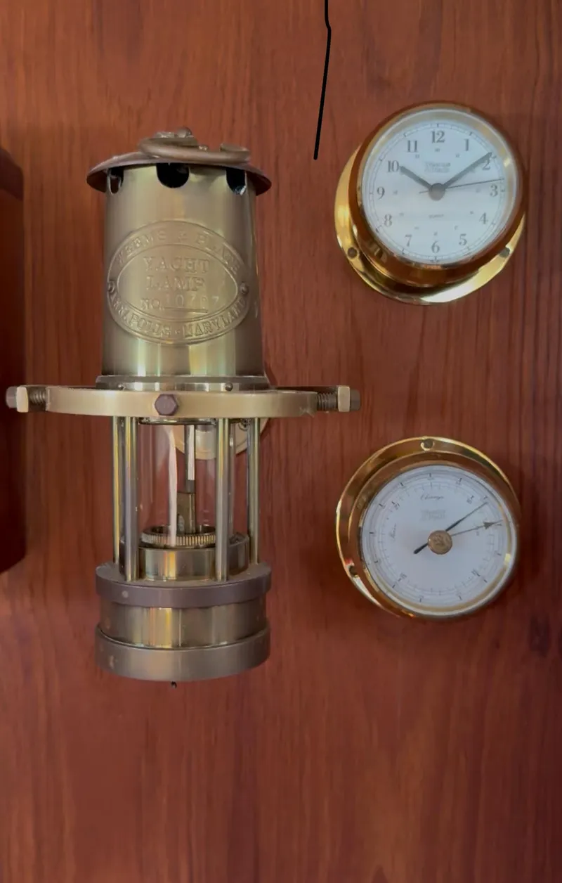 Slide: The Image of Brass nautical instruments on Pacific Seacraft Crealock 34, 1993, featuring clock and barometer. - 49