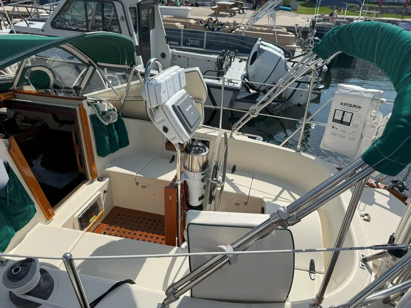Slide: The Image of 1993 Pacific Seacraft Crealock 34 sailboat cockpit with green canopy and navigation equipment. - 5