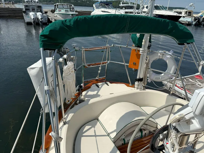 Slide: The Image of 1993 Pacific Seacraft Crealock 34 sailboat cockpit with green canopy, docked at marina. - 6