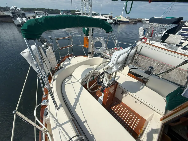 Slide: The Image of 1993 Pacific Seacraft Crealock 34 sailboat cockpit with green canopy, docked at marina. - 7