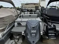 Slide: The Image of 2025 Bennington 25 QXSBA boat with 300 V6 engine, docked among other boats. - 12