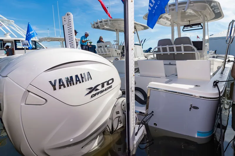 Slide: The Image of 2026 Regulator 26XO boat with Yamaha XTO Offshore engine at a marina display. - 11