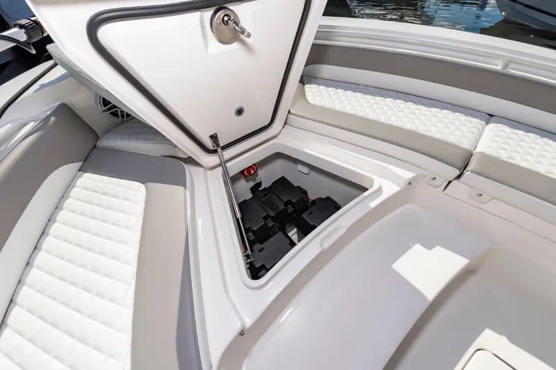 Slide: The Image of 2026 Regulator 26XO boat storage compartment with open hatch and cushioned seating. - 17