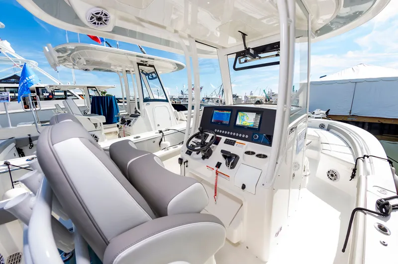 Slide: The Image of 2026 Regulator 26XO boat interior with modern helm and seating at a marina. - 4
