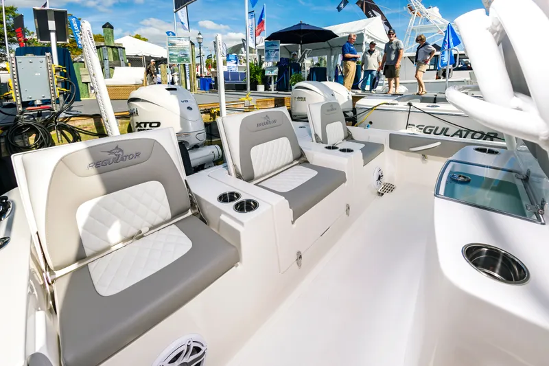 Slide: The Image of 2026 Regulator 26XO boat interior with seating and Yamaha engines at a boat show. - 8