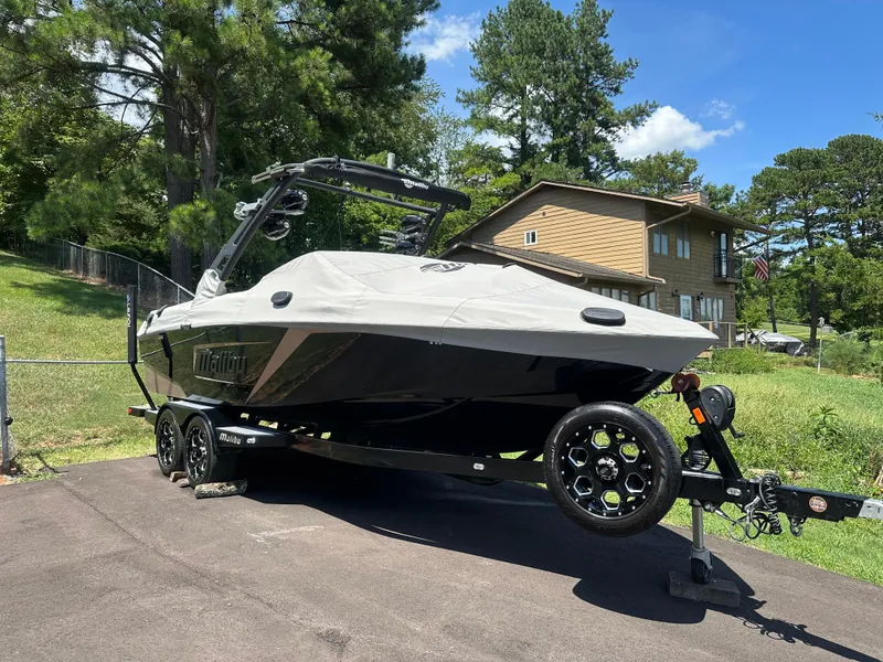 Slide: The Image of 2020 Malibu Wakesetter 23 LSV boat on trailer, covered, in a residential driveway. - 0