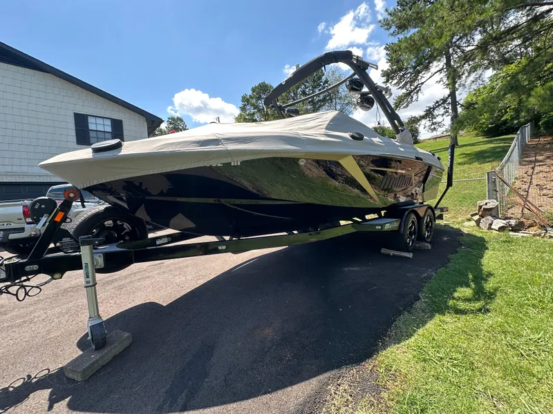 Slide: The Image of 2020 Malibu Wakesetter 23 LSV boat on trailer, parked outdoors on a sunny day. - 2