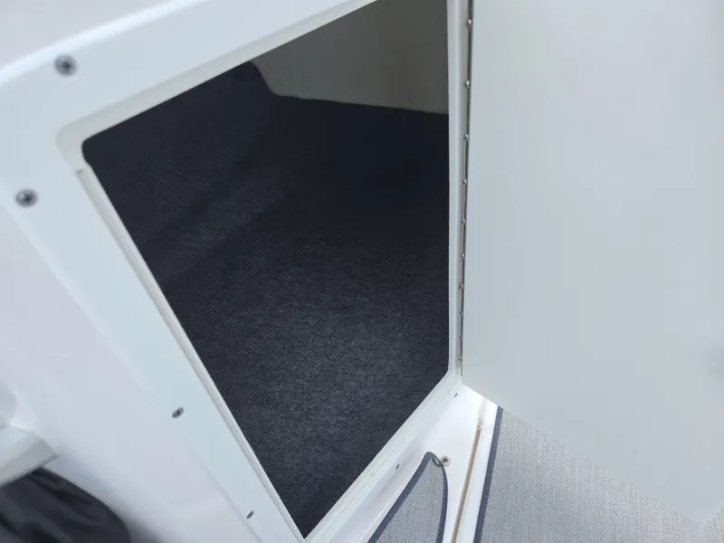 Slide: The Image of 2021 Yamaha Boats SX195 storage compartment with open door, showcasing interior space. - 13