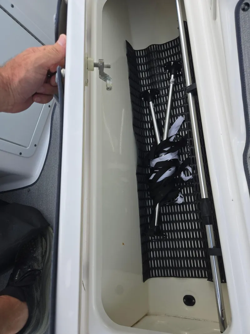 Slide: The Image of Open storage compartment in 2021 Yamaha SX195 boat with equipment inside. - 14