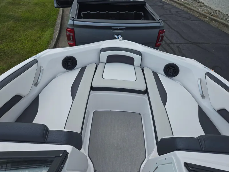Slide: The Image of 2021 Yamaha SX195 boat interior with cushioned seating and speakers, parked near a truck. - 16
